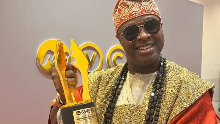 Femi Adebayo holding his award as the best lead actor for his movie 'Seven doors'